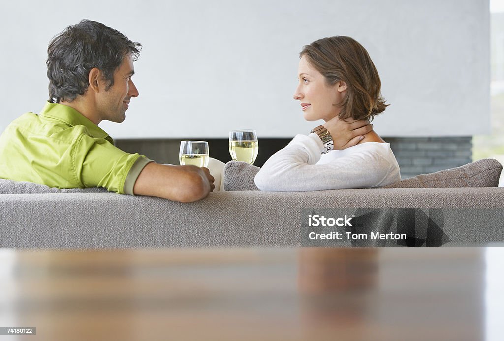 Mann und Frau sitzen auf der Couch mit einem Glas Wein - Lizenzfrei 25-29 Jahre Stock-Foto