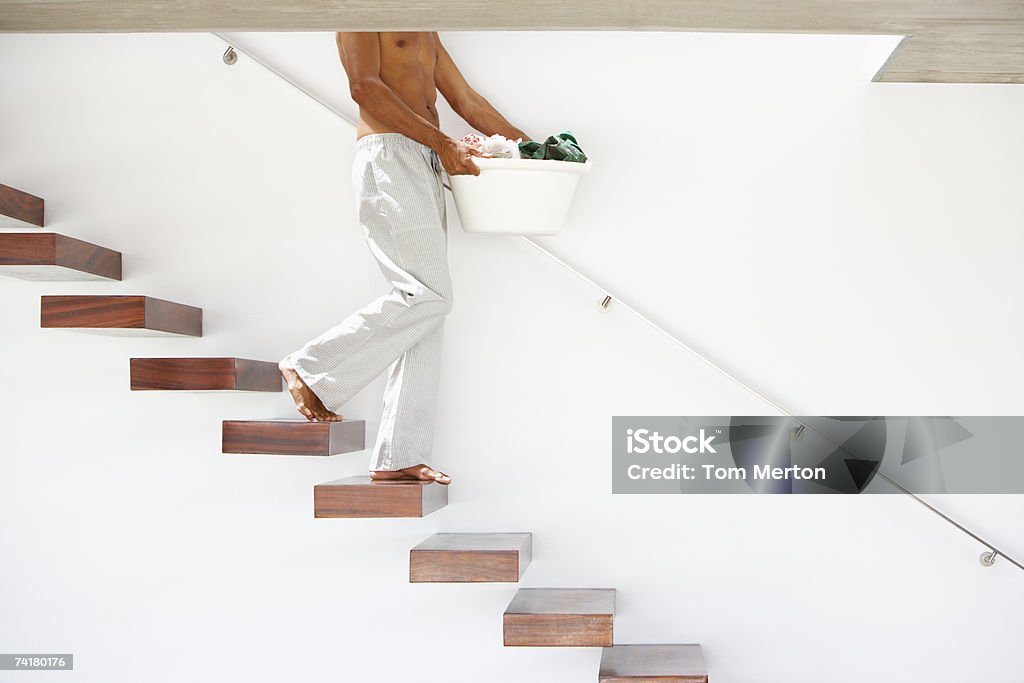 Człowiek chodzenie w dół po schodach z Kosz na pranie - Zbiór zdjęć royalty-free (30-34 lata)