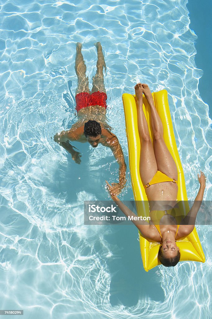 Женщина на flotation устройства и человек, плавание в бассейне - Стоковые фото Бассейн роялти-фри