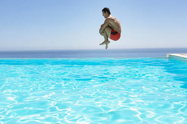 Photo of Man leaping into infinity pool