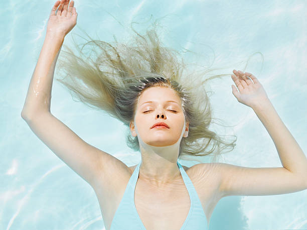 女性水に浮かぶ - halter top ストックフォトと画像