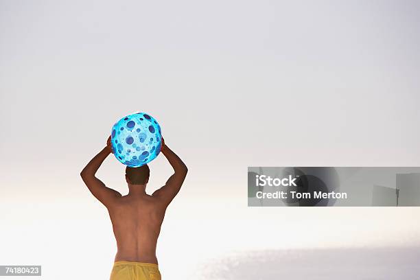 Человек В Купальнике С Пляжный Мяч Вид Сзади — стоковые фотографии и другие картинки 20-24 года - 20-24 года, Вид сзади, Выше пояса