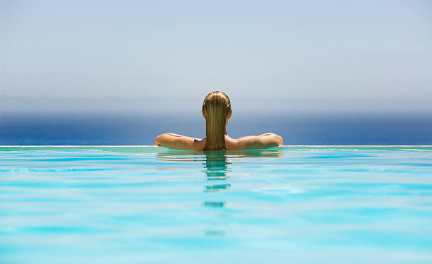 mujer en la piscina de borde infinito - clothing human age viewpoint horizontal fotografías e imágenes de stock