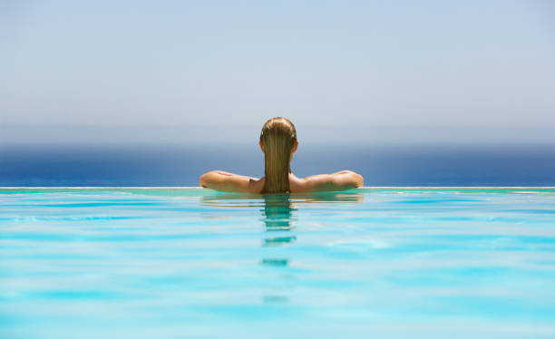 Woman in infinity pool  in and out stock pictures, royalty-free photos & images