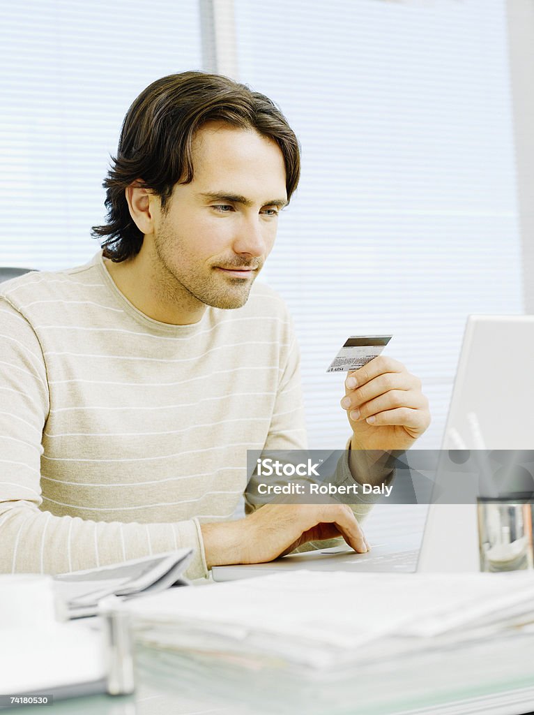 Uomo d'affari con una carta di credito e computer - Foto stock royalty-free di 25-29 anni