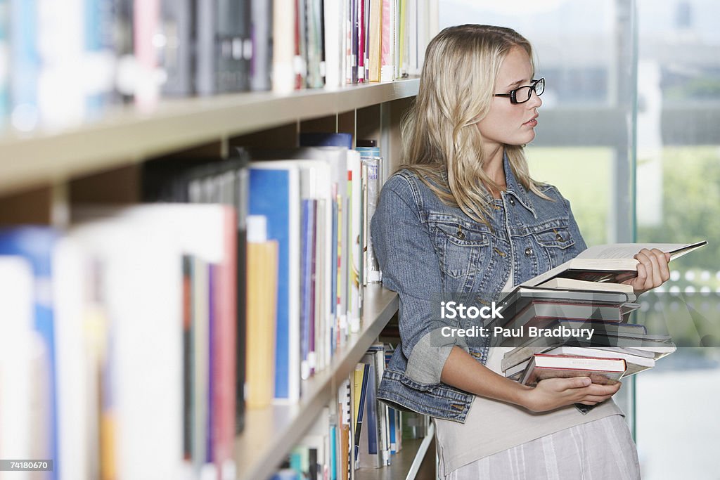 Jeune femme dans la bibliothèque avec des livres à l'école - Photo de Livre libre de droits