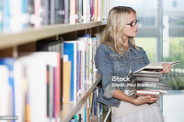 Foto de Jovem Mulher Na Biblioteca Com Livros Escolares e mais fotos de stock de Livro - Livro, Óculos, 18-19 Anos