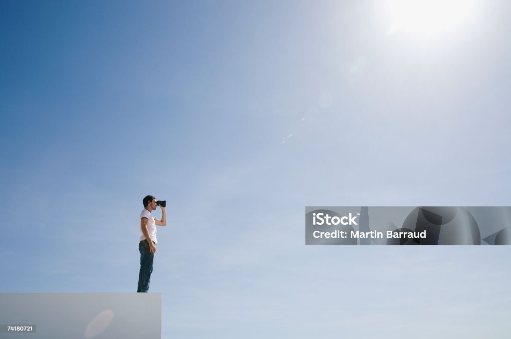 Homem em pedestal com binóculos e céu azul ao ar livre - Royalty-free Binóculos Foto de stock