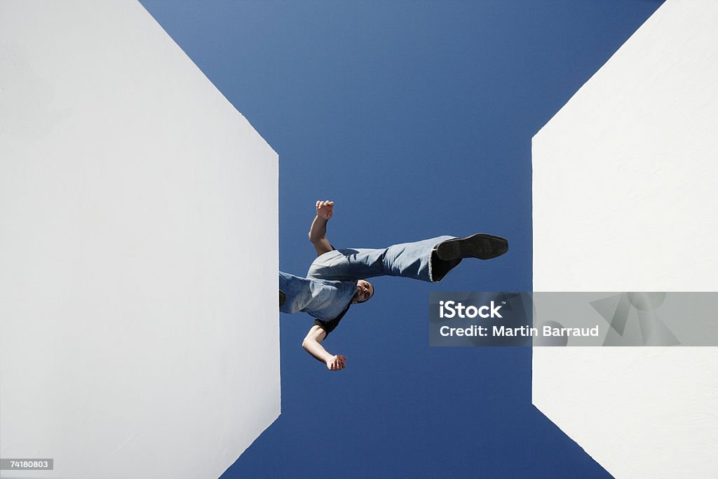 Low angle view of man walking across high gap outdoors  Connection Stock Photo