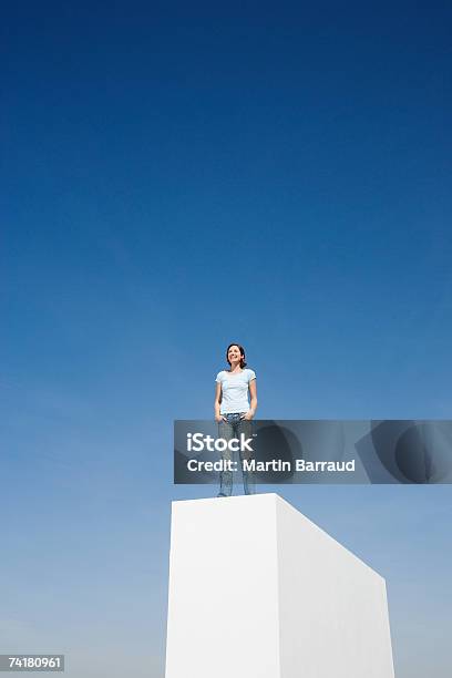 Photo libre de droit de Femme Debout Sur Le Mur À Lextérieur Avec Ciel Bleu banque d'images et plus d'images libres de droit de 25-29 ans