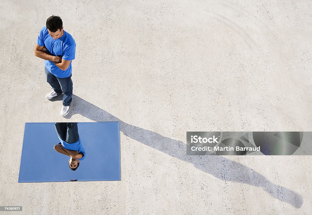 Mann stehend mit Spiegel auf Boden und Reflexion - Lizenzfrei Spiegel Stock-Foto