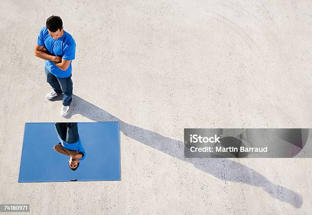 Mann Stehend Mit Spiegel Auf Boden Und Reflexion Stockfoto und mehr Bilder von Spiegel - Spiegel, Betrachtung, Spiegelung