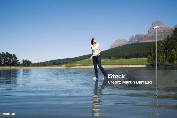 Donna In Piedi In Acqua Con Telecamera Di Sorveglianza E Alberi - Fotografie stock e altre immagini di 25-29 anni