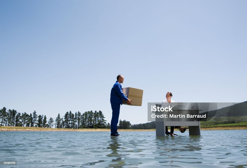 Homme proposer Boîte en carton de femme au bureau sur l'eau - Photo de 20-24 ans libre de droits