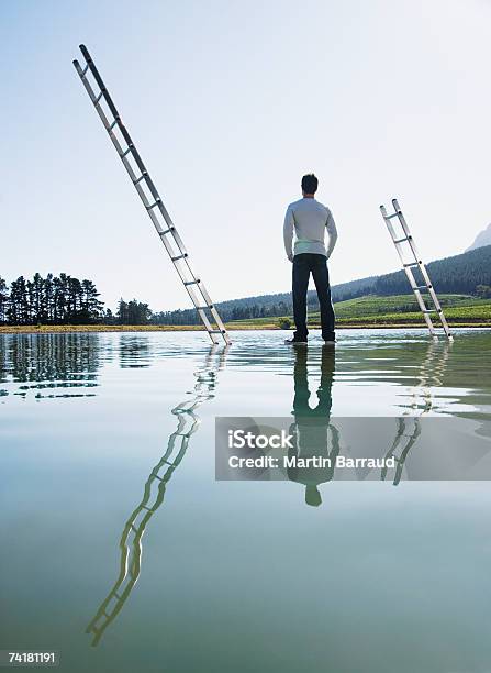 Photo libre de droit de Homme Debout Sur Les Échelles De Leau Avec banque d'images et plus d'images libres de droit de 25-29 ans - 25-29 ans, Beauté de la nature, Bleu