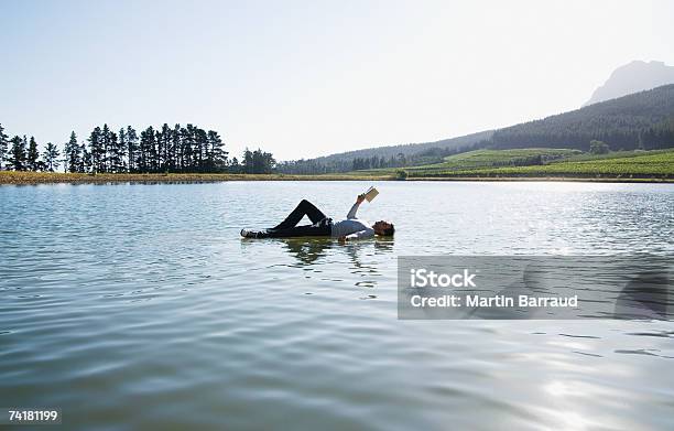 Hombre Acostado En Agua Libro De Lectura Foto de stock y más banco de imágenes de 25-29 años - 25-29 años, Acostado, Azul