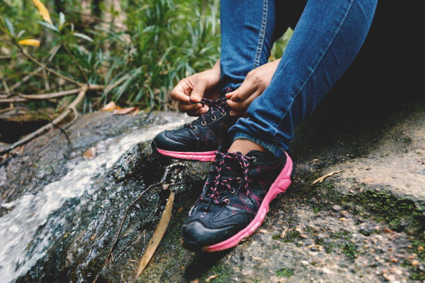 istock Low Section Of Man Tying Shoelace While Sitting On Rock 743734713