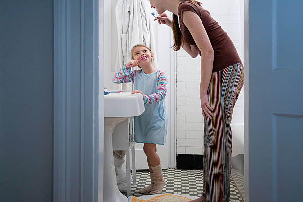 Mother and daughter brushing teeth  brushing teeth stock pictures, royalty-free photos & images