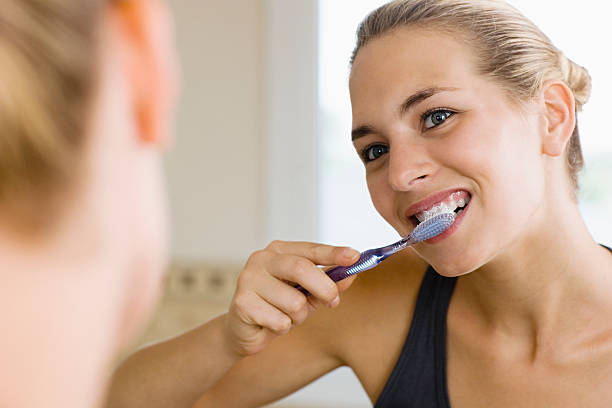mulher lavar os dentes - brushing teeth women toothbrush brushing imagens e fotografias de stock