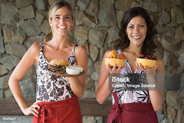 Junge Frauen Mit Schalen Von Speisen Stockfoto und mehr Bilder von Geben - Geben, Olive, Schüssel