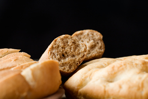 Different types of bread on the black background. Copy space. Close-up.