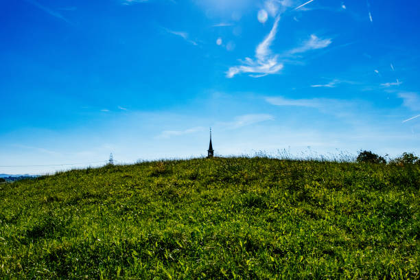 View of a lone church steeple over the meadows