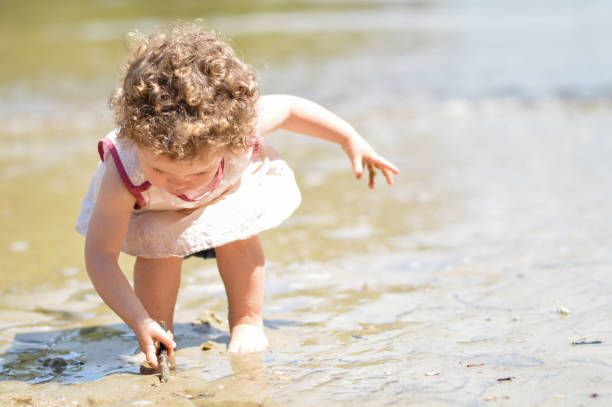 istock Girl Playing With Stick In Muddy Water 746126835