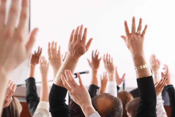 istock Cropped Image Of Hands Raised At Seminar 748581231