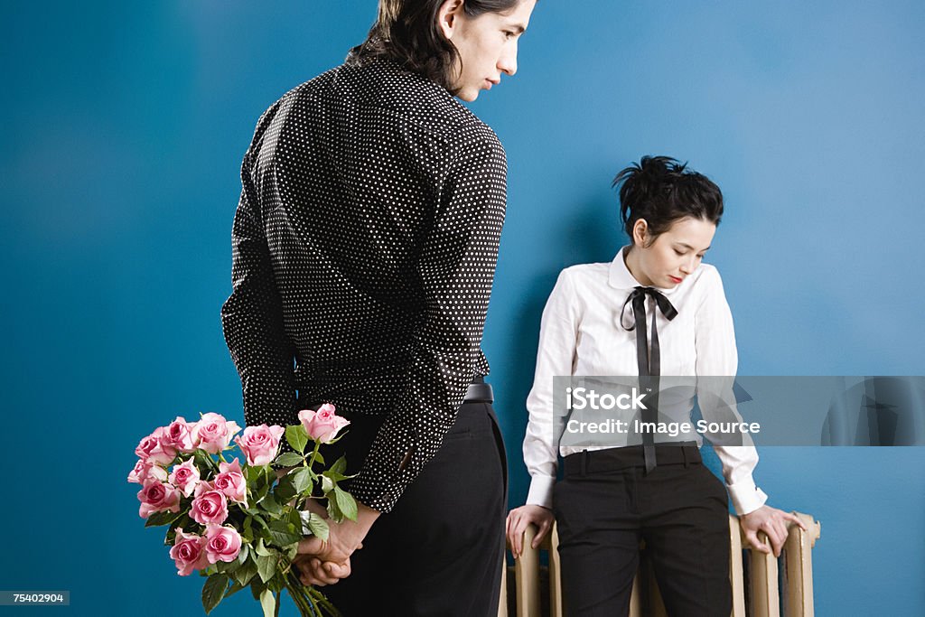 Jeune homme avec des roses pour jeune femme - Photo de Derrière libre de droits