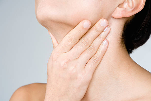 woman touching her neck - boğaz ağrısı stok fotoğraflar ve resimler