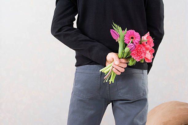 Man holding flowers behind back  hands behind back stock pictures, royalty-free photos & images