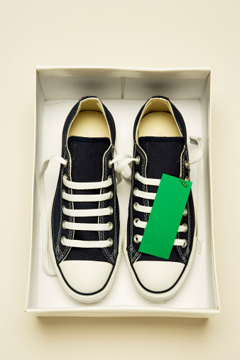 Casual sports white lace-up sneakers in leather with green design details. New shoes on a white background.