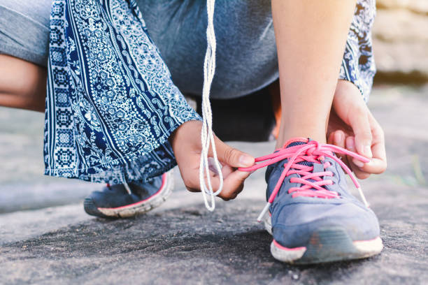 istock Low Section Of Girl Tying Shoelace 755743539