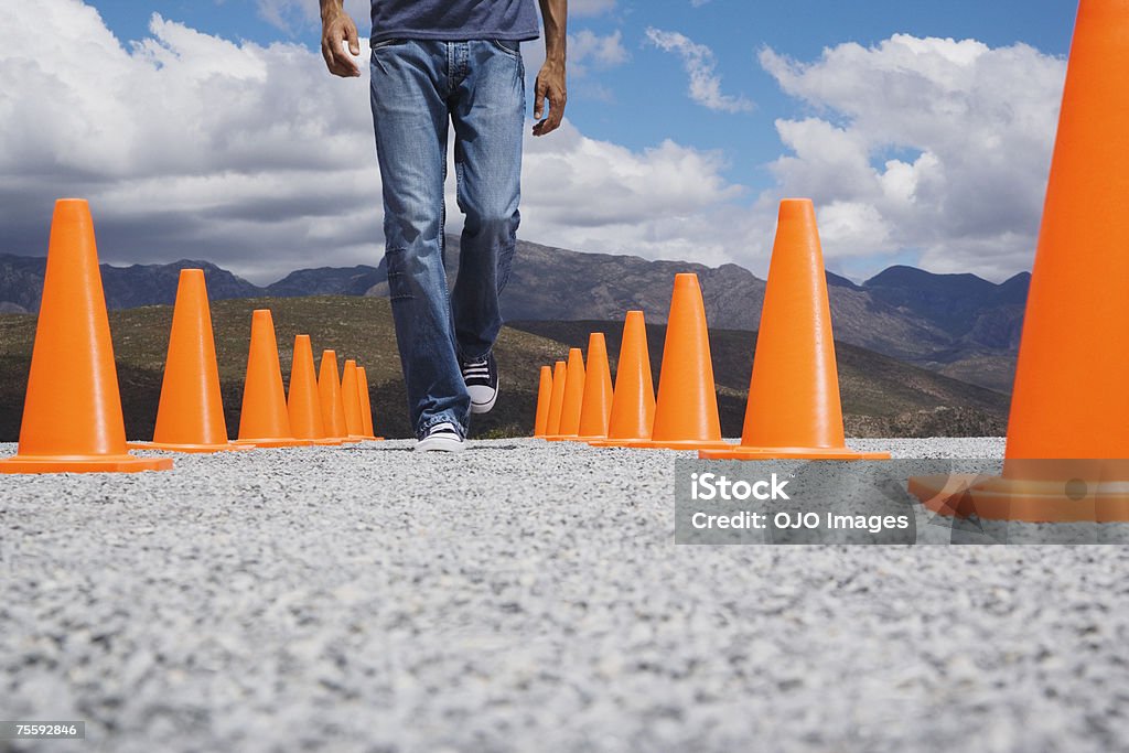Homme marchant entre deux rangées de cônes de sécurité - Photo de 30-34 ans libre de droits