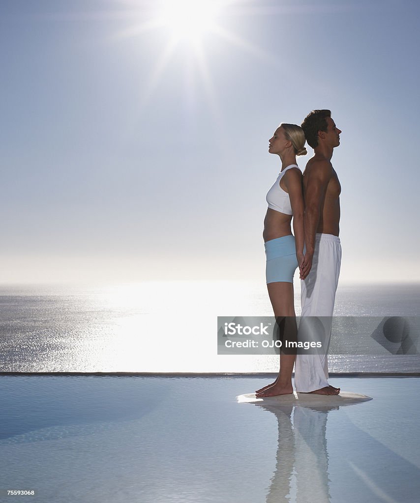 Un homme et femme dos à dos en eaux calmes - Photo de Dos à dos libre de droits