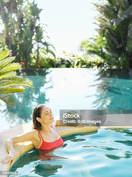 Donna Rilassante Nella Vasca Idromassaggio - Fotografie stock e altre immagini di Infinity pool - Infinity pool, Palma, Piscina