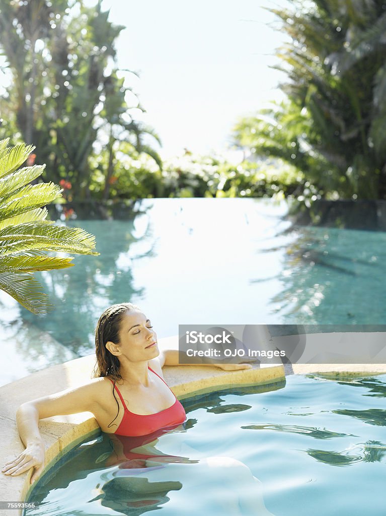 Mulher relaxante em uma banheira de hidromassagem - Foto de stock de Lago infinito royalty-free