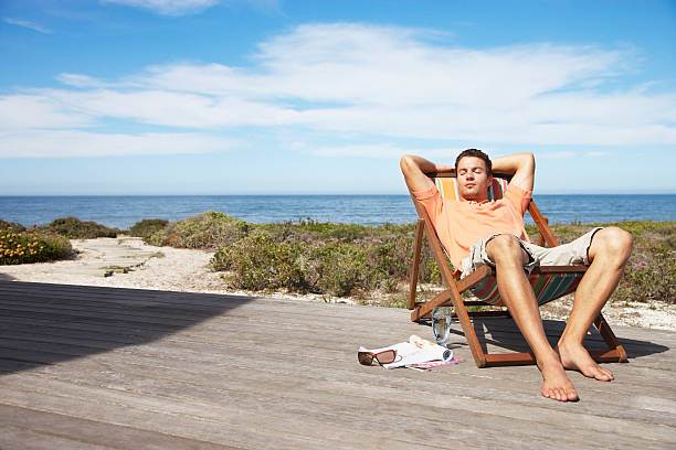 Man relaxing in a lounge chair  beach relax stock pictures, royalty-free photos & images