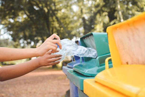 istock Cropped Image Of Hands Throwing Crushed Bottles In Recycling Bin 758479059