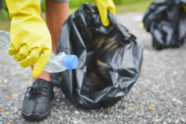 istock Person Holding Crushed Plastic Bottle And Garbage Bag While Standing On Street 758479117