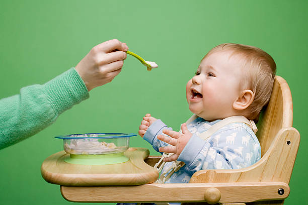 adult feeding baby - baby eating child mother стоковые фото и изображения