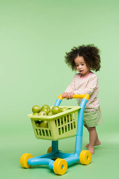 menina com maçãs no carrinho de compras - carrinho de criança - fotografias e filmes do acervo