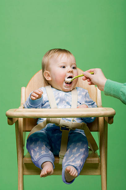 nourrir bébé adulte - baby eating child mother photos et images de collection