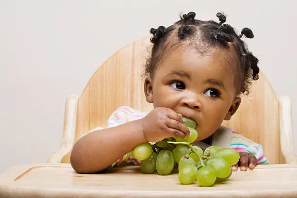 Photo of Baby girl eating grapes