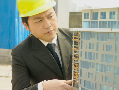 Happy man, architect and tablet on mockup in construction planning against a studio background. Male person, engineer or contractor smile with technology and blueprint in project or architecture plan