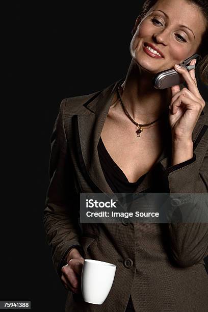 Businesswoman On Cellphone With Coffee Stock Photo - Download Image Now - Adults Only, Black Background, Business