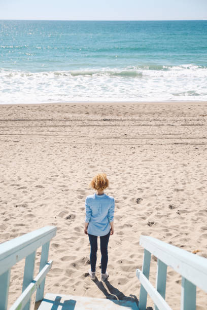 istock Rear View Of Woman Standing On Beach 763235231