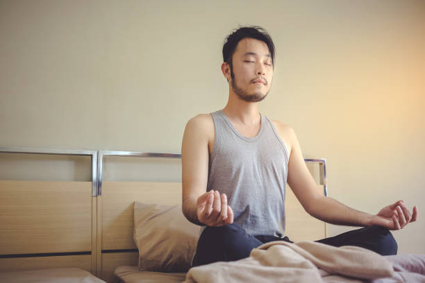 istock Young Man Practicing Lotus Position On Bed At Home 763238405