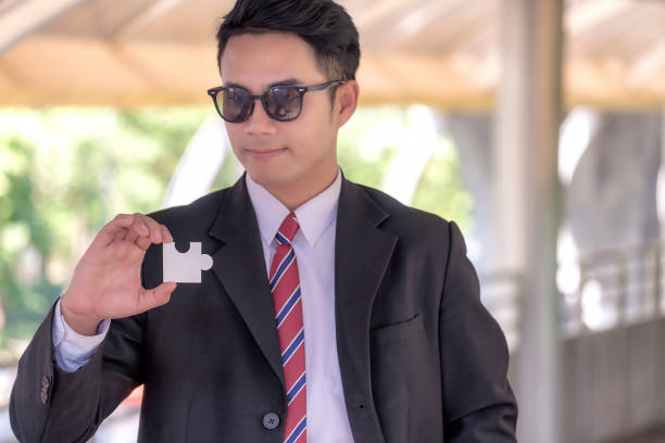 istock Handsome Businessman Holding Jigsaw Puzzle 763289549