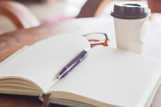 istock High Angle View Of Book With Pen And Eyeglasses By Coffee Mug On Table 767982247